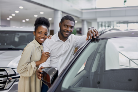 A happy couple with their new vehicle.