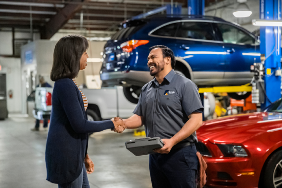 A service technician talking with a vehicle owner.